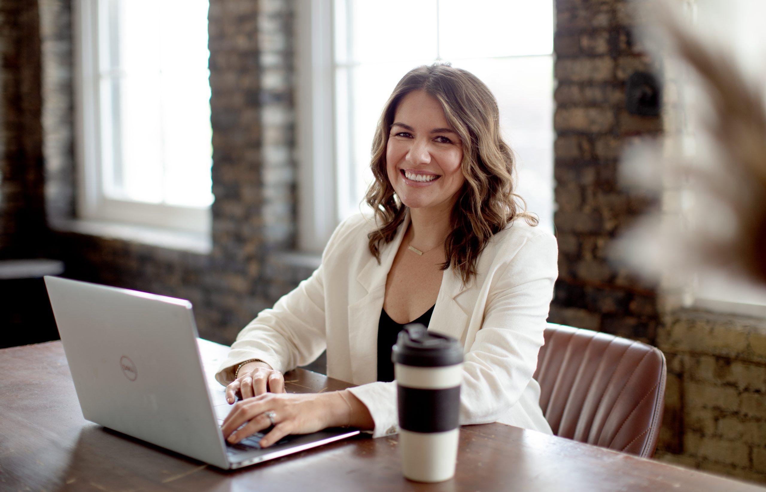 Photo of a woman working in an office setting with a laptop in front of her