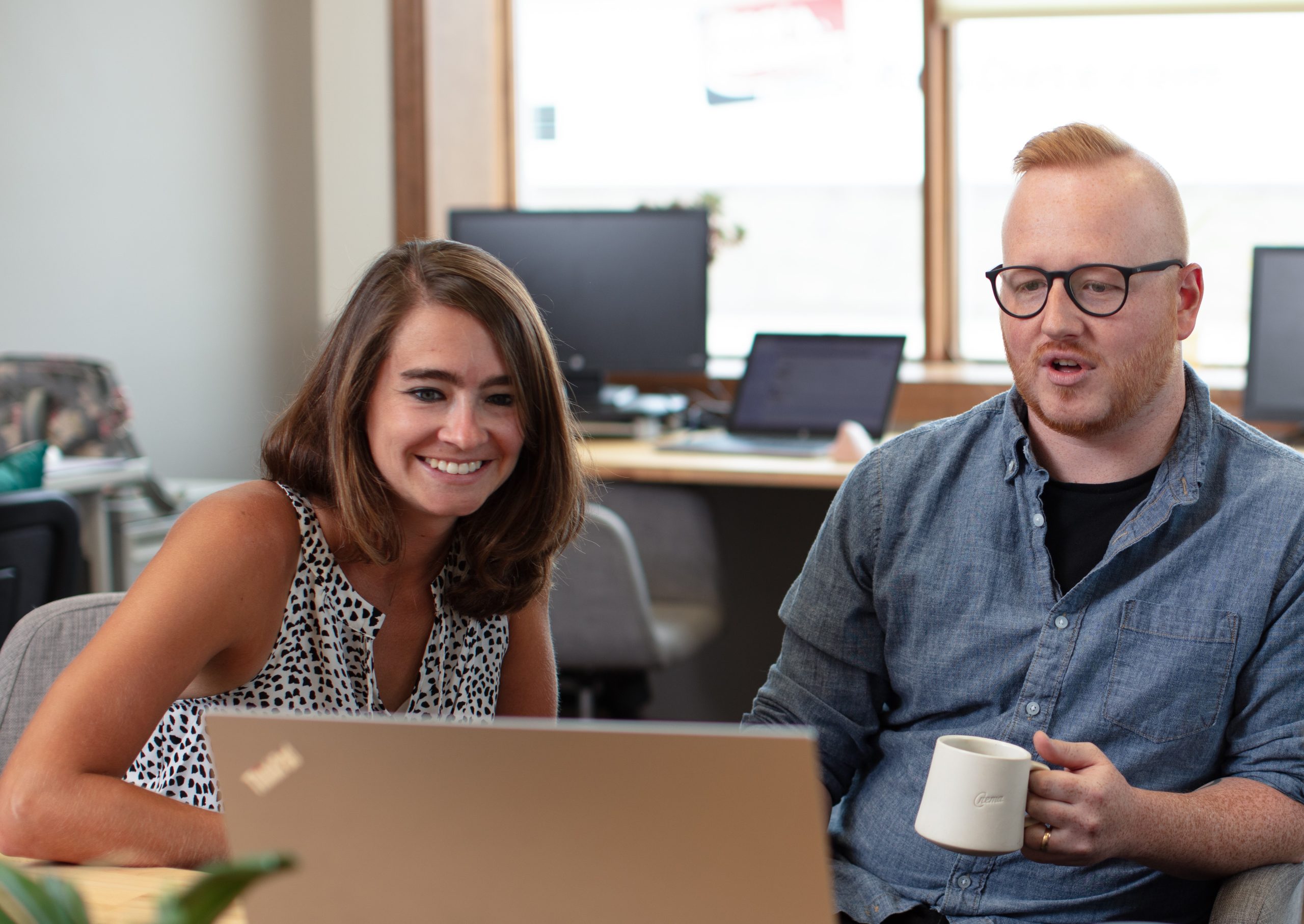 Photo of two people working together in an office setting