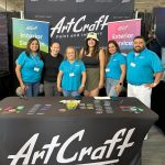 Photo of six people standing at a trade show booth