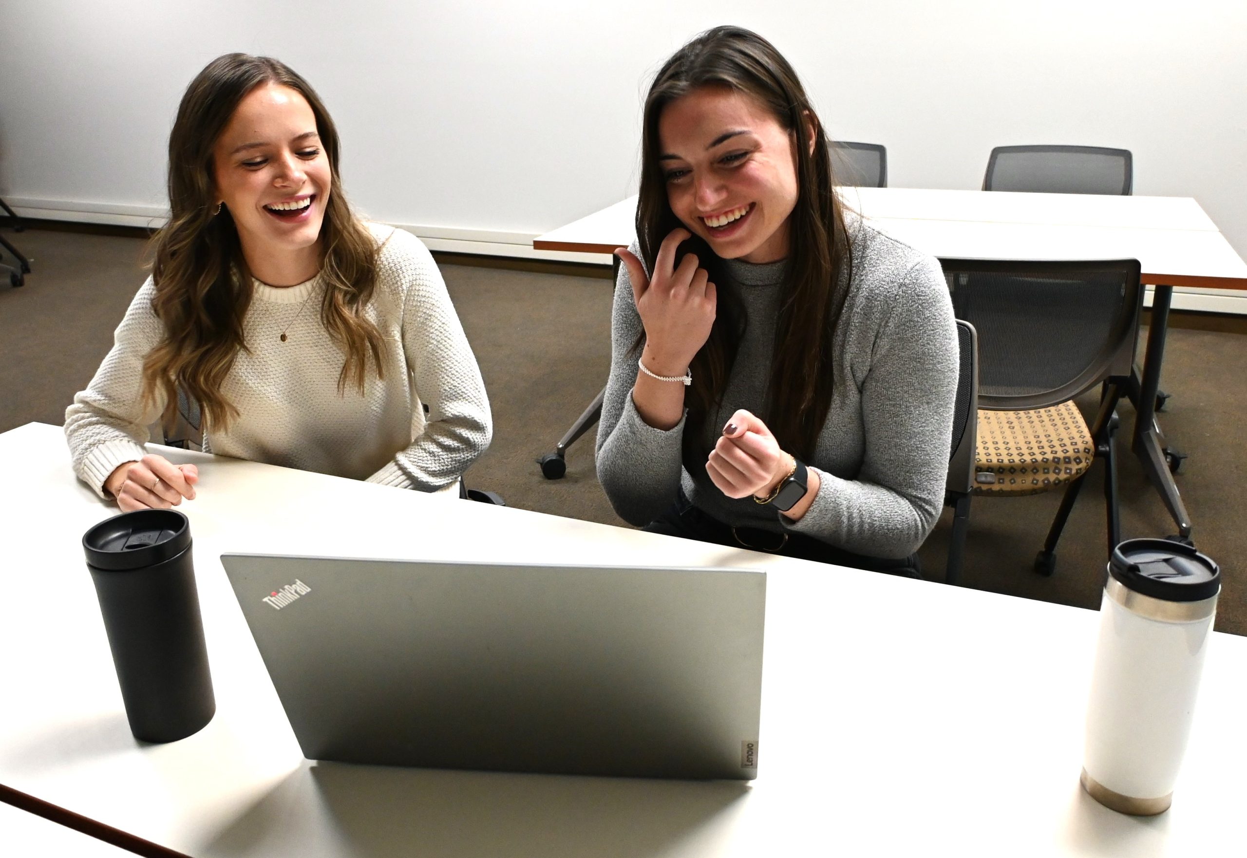 Hannah Lohrenz and Morgan Goeden in the office laughing.